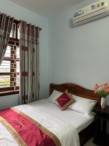 um quarto com uma cama e uma janela em RUBY HOMESTAY em Hue