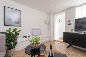 a living room with a couch and a tv at Cityscape Charm Studio - Central London in London