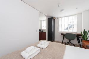 a bedroom with a bed with two towels on it at Cityscape Charm Studio - Central London in London
