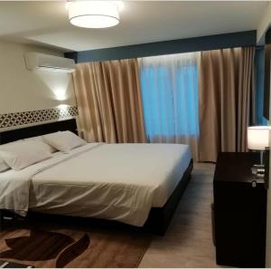 Un dormitorio con una cama grande y una ventana en Hotel Primavera, en Amadora