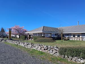 a building with a stone wall in front of a building at Lutea in Riom-ès-Montagnes