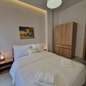 una camera da letto con un grande letto bianco con due asciugamani di N&S Apartment A a Édessa