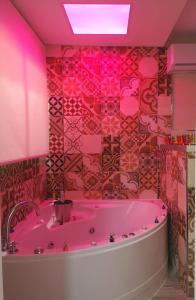 Baño rosa con bañera y techo rosa en ERES EMÉRITA "Apartamentos & Suites" en Merida