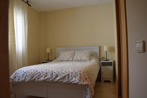 a bedroom with a bed and two lamps and a window at La abuela Isabel Piso con encanto Arnedillo in Arnedillo