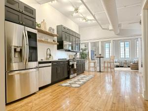 a kitchen with black cabinets and stainless steel appliances at The Historic Lyric Presidential Suite in Cincinnati