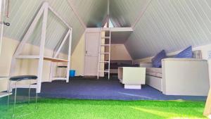 a room with a loft bed and green carpet at Giggling Goons Cabins & Kitchen in Kasol