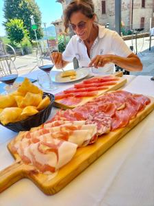 a woman sitting at a table with a tray of food at App.to Pian del Ronco in Pellegrino Parmense