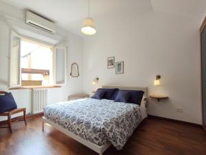 - une chambre blanche avec un lit et une fenêtre dans l'établissement A casa di Kika, à Bologne