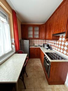 uma cozinha com armários de madeira, uma mesa e um fogão em Backstage em Gyor