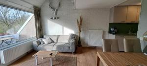 a living room with a couch and a table at Appartement Bru Zeeland in Bruinisse
