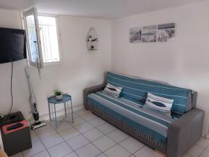 a living room with a couch and a table at Le Bleu du Sud in Gruissan