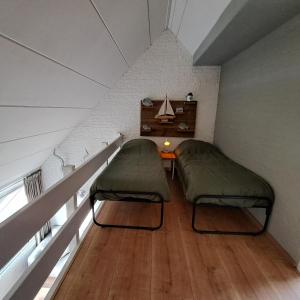 Habitación con 2 camas y mesa en el ático en Appartement Bru Zeeland en Bruinisse