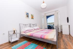 - une chambre avec un grand lit et une fenêtre dans l'établissement Apartman PANTAN, à Trogir