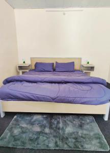 a bed with purple pillows on it in a room at Giggling Goons Cabins & Kitchen in Kasol +13 photos