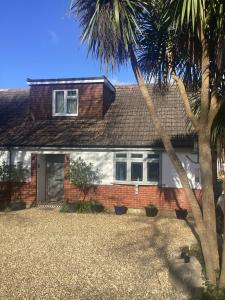 una casa con una palma di fronte di Godden Green B & B Guesthouse a Newchurch