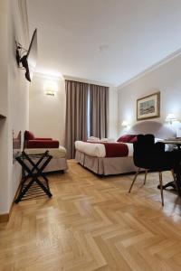 ローマにあるAffittacamere Boncompagni Suiteのベッド2台とデスクが備わるホテルルームです。