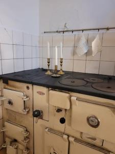 una vieja estufa con dos velas encima en Torpet, en Liden