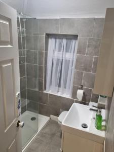 a bathroom with a shower and a toilet and a sink at Comfy 1st floor flat, sleeps 4 in London