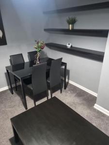 ein Esszimmer mit einem schwarzen Tisch und schwarzen Stühlen in der Unterkunft Comfy 1st floor flat, sleeps 4 in London