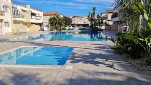 a swimming pool in the middle of a apartment complex at The Olive Grove Escape, Eleonas Apts in Sotira