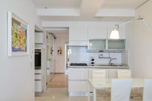 a kitchen with white cabinets and a table and chairs at Mari Lifestyle in Fano