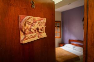 drewniane drzwi z obrazem obok łóżka w obiekcie Pousada Jardon Ubatuba w mieście Ubatuba