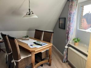 a dining room table with chairs and a window at Ferienwohnung Karen&Lemmi in Risum-Lindholm