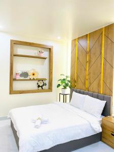 una camera da letto con un grande letto bianco e uno specchio di Agape Hotel & Căn hộ Đà Lạt a Da Lat