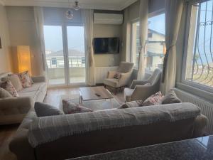 a living room with a couch and chairs and a tv at Yalova Apartments in Yalova