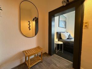 un corridoio con specchio e divano in una camera di Apartment Goethe in der Göttinger Innenstadt a Gottinga