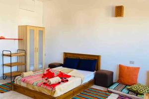 a bedroom with a large bed with red items on it at Lighthouse studio in Dahab