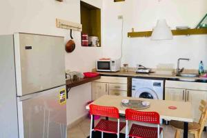 a kitchen with a refrigerator and a table with red chairs at Lighthouse studio in Dahab