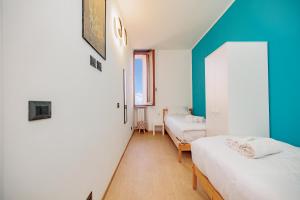 Una habitación con dos camas y una pared azul. en Martesana Guest House, en Milán
