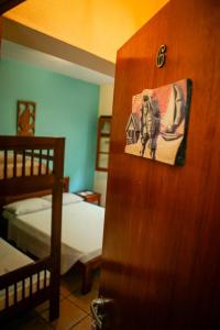 a bedroom with a bed and a door with a picture of an elephant at Pousada Jardon Ubatuba in Ubatuba