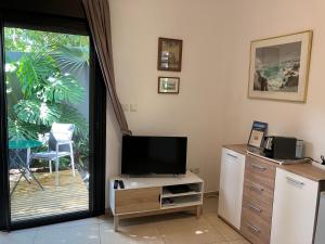 a living room with a tv and a desk with a television at La Carangaise in Saint-Pierre