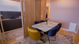 a dining room with a table and yellow chairs at Green Ilidza Apartment in Sarajevo