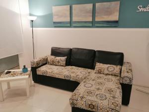 uma sala de estar com um sofá preto e uma mesa em Smile's Home em Catânia