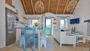 a kitchen with a blue and white table and chairs at Seeperdjie in Struisbaai