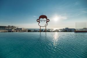 a sign with a monkey on a pole in the water at Blu Monkey Hub and Hotel Bangsaen in Ban Bang Saen (1)