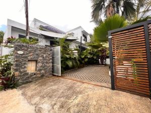 a house with a wooden gate in front of it at La Carangaise in Saint-Pierre