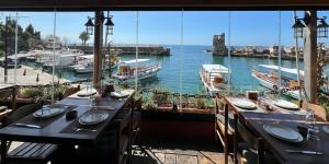 een restaurant met uitzicht op het water en de boten bij Bab El Mina guest house Byblos in Jbeil