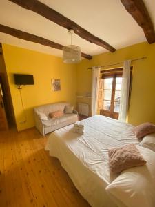 ein Schlafzimmer mit einem großen weißen Bett und einem Sofa in der Unterkunft Hotel Restaurante Agapio de TRESNIÑO in Quintanilla de Onésimo