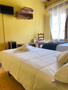 a bedroom with two beds and a tv and a window at Hotel Restaurante Agapio de TRESNIÑO in Quintanilla de Onésimo