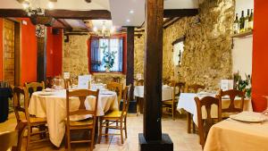 a restaurant with tables and chairs in a room at Hotel Restaurante Agapio de TRESNIÑO in Quintanilla de Onésimo