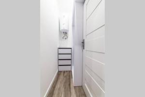 korytarz z białymi drzwiami i drewnianą podłogą w obiekcie Apartament Staszica w Radomiu