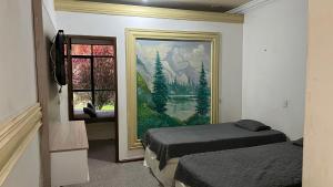 a bedroom with two beds and a painting on the wall at Ytacaranha Hotel de Serra in Meruoca