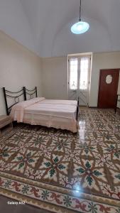 ein Schlafzimmer mit einem Bett und einem Teppich auf dem Boden in der Unterkunft Casa vacanza Salento in Aradeo