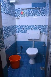 bagno blu con servizi igienici e secchio di Amudha Hotels & Restaurant a Yercaud