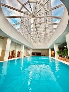 a large swimming pool with a ceiling of blue water at Skopje Sky City 19th Floor Twin Apartments with Indoor Pool & Spa & Fitness Including in Price in Skopje