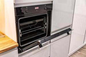 an oven in a kitchen with a white refrigerator at Apartament Staszica in Radom